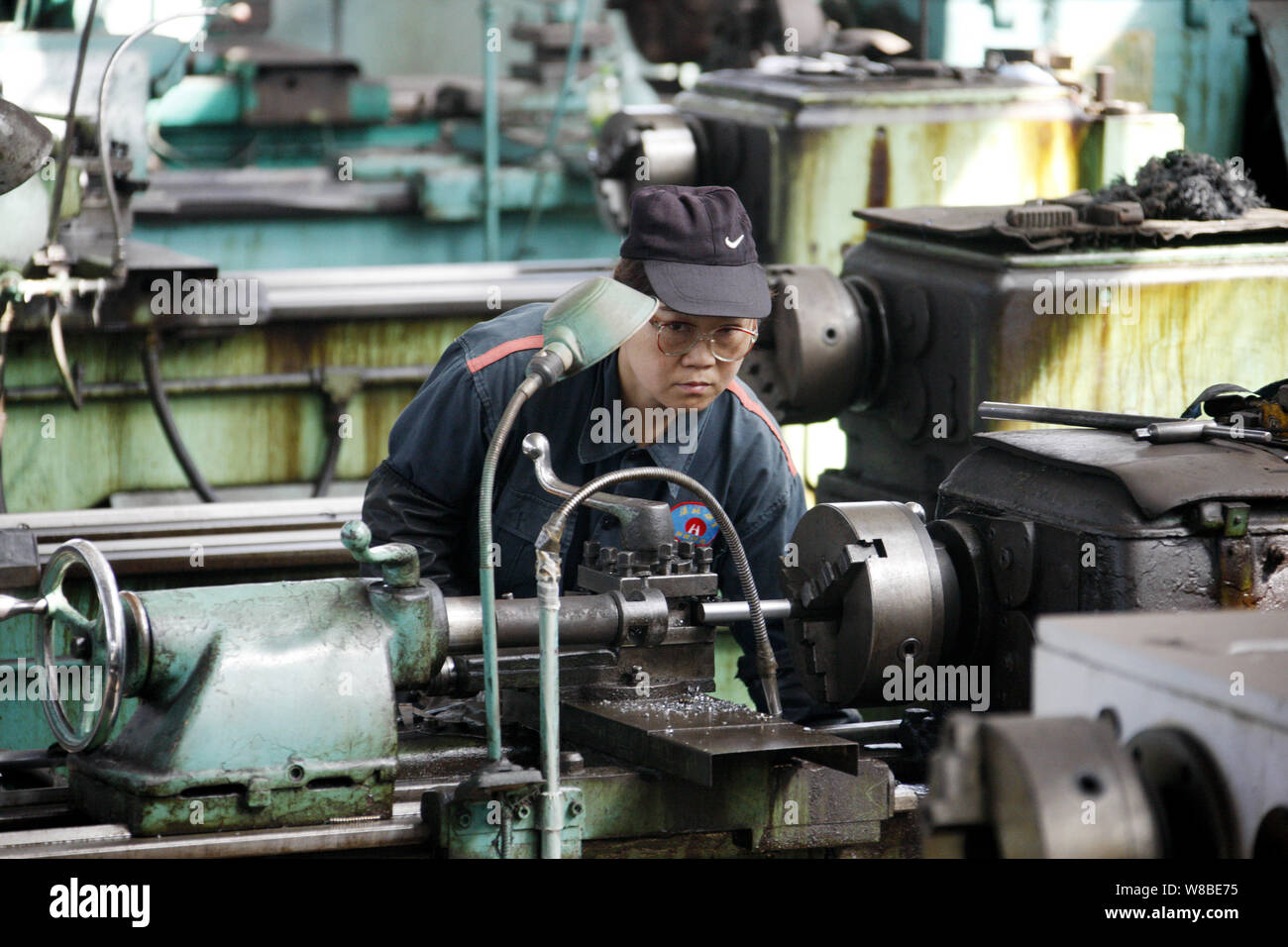 ---- Eine weibliche chinesischer Arbeiter Prozesse ein Stahl Produkt in einer Anlage in Stadt Huaibei, der ostchinesischen Provinz Anhui, 1. April 2016. Festland China aus Stockfoto