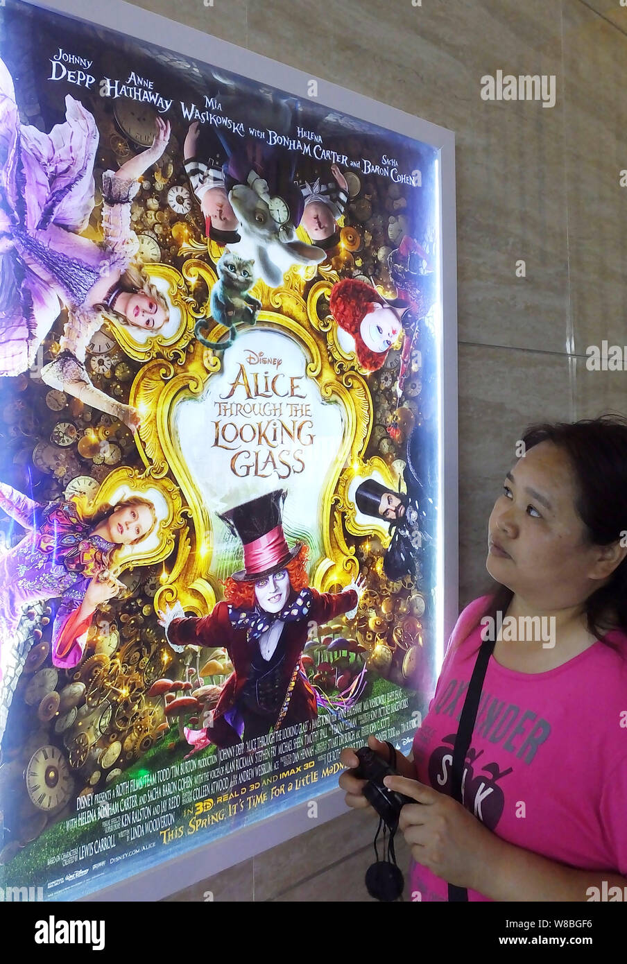 Eine Chinesische filmgoer betrachtet ein Plakat des Films "Alice Through the Looking Glass" in einem Kino in Kunshan City, Chinas Provinz Hubei, 25 Ma Stockfoto