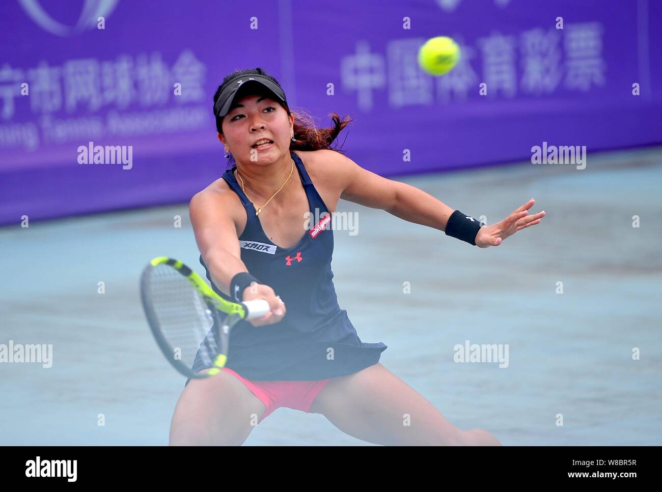 Riko Sawayanagi von Japan gibt einen Schuß zu Xu Shilin Chinas in singles ihre Frauen Match während der 2016 des ITF-Frauen-Nanning in Nanning Stockfoto