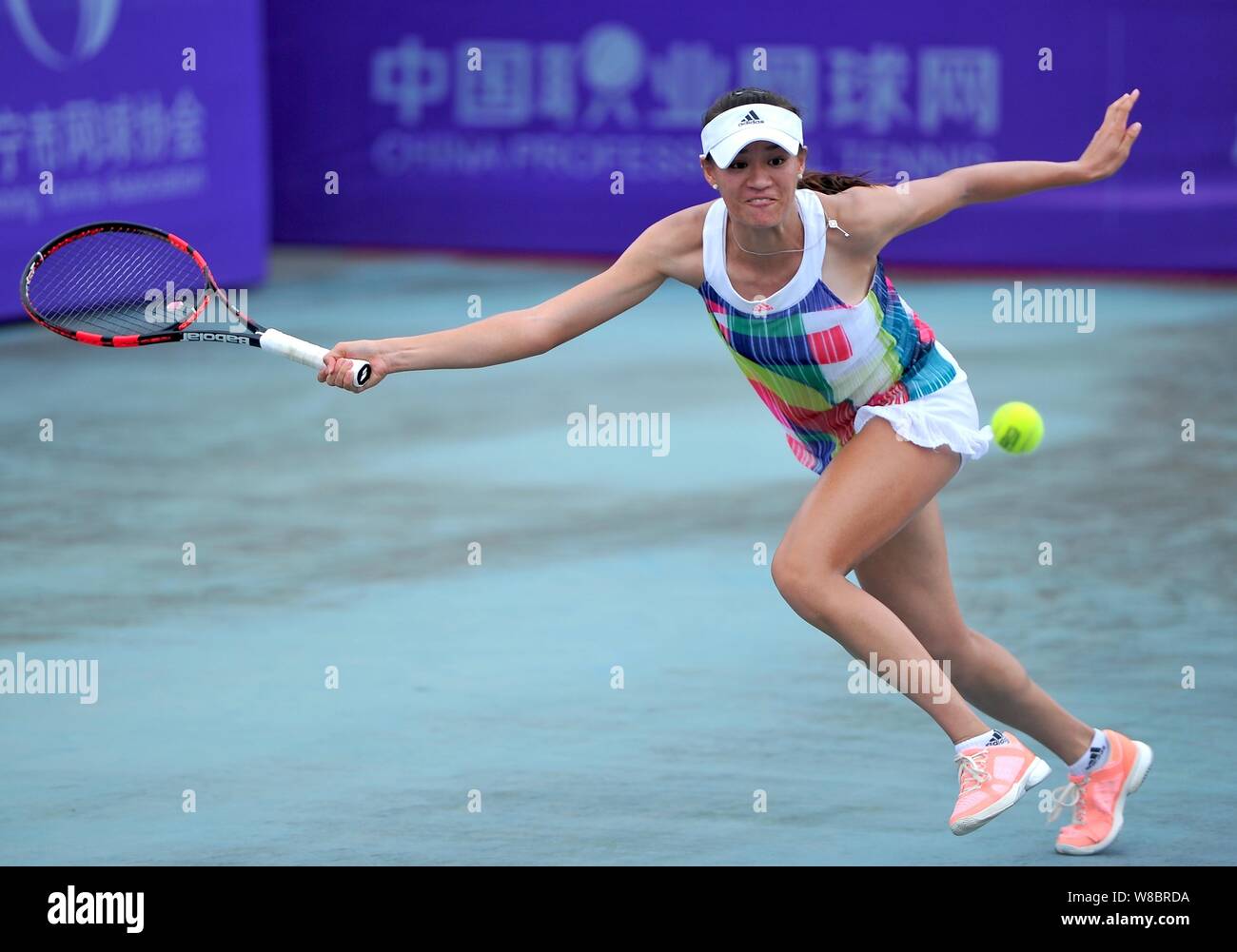 Xu Shilin von China liefert einen Schuß zu Riko Sawayanagi Japans in ihre Frauen singles Match während der 2016 des ITF-Frauen-Nanning in Nanning Stockfoto