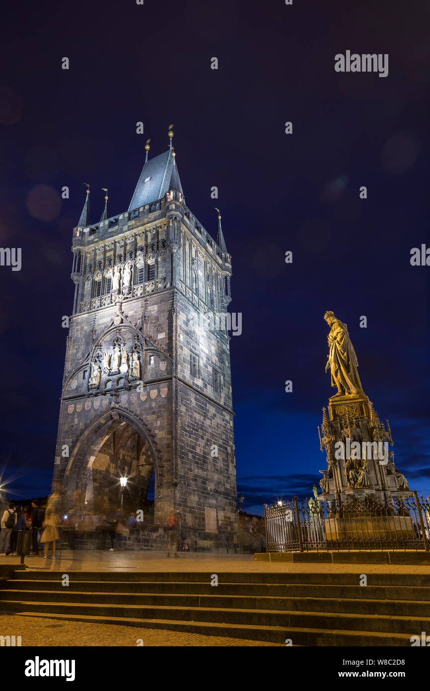 Verschwommene Bewegung von Menschen in der Nähe der beleuchteten Altstädter Brückenturm und die Statue von Karl IV. In der Altstadt in Prag, Tschechische Republik, am Abend Stockfoto