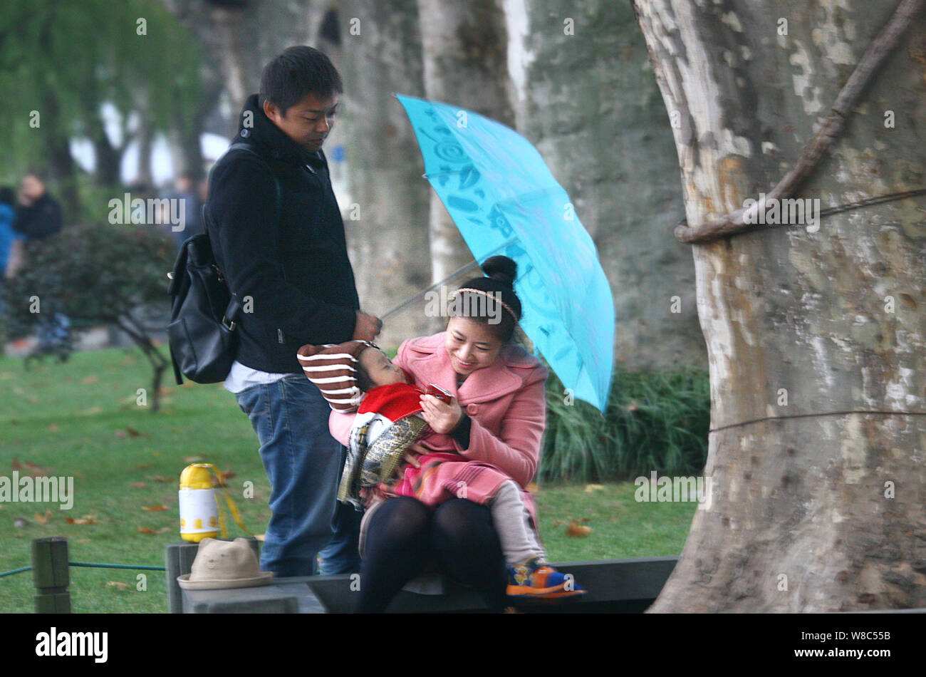---- Eine chinesische Paare und ihre einzige Tochter sind in einem Park in Hangzhou city gesehen, East China Zhejiang provinz, 14. November 2013. Fast ein Stockfoto