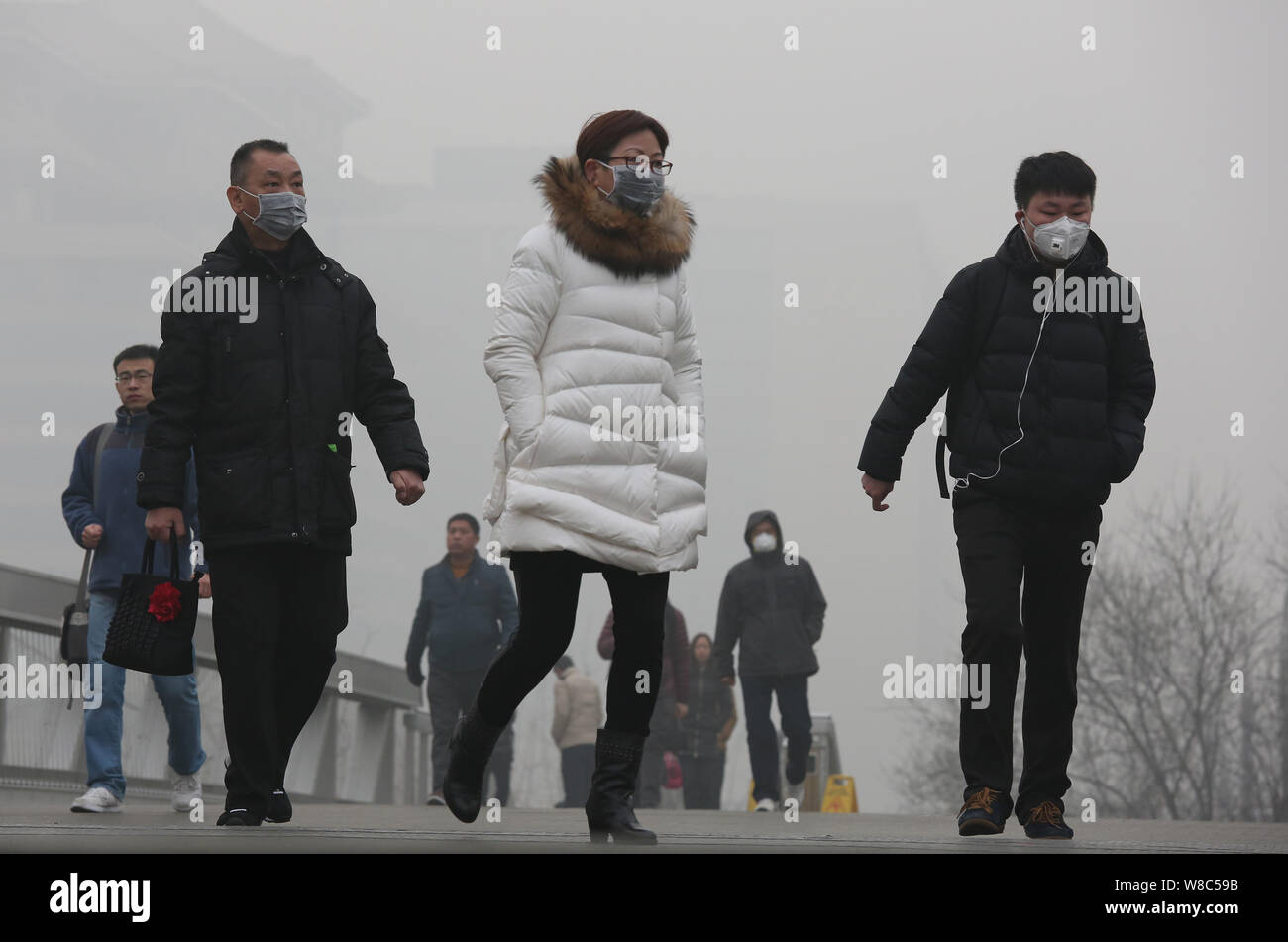 ---- Fußgänger, von denen die meisten Gesicht-masken tragen, zu Fuß auf einer Straße in heavy Smog in Peking, China, 25. Dezember 2015. Peking Bewohner mehr gekauft Stockfoto