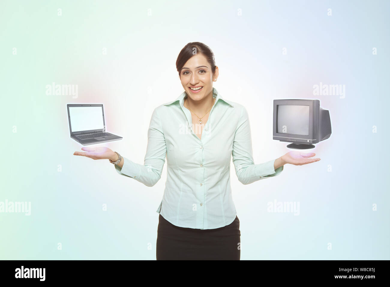 Geschäftsfrau beim Vergleich von Notebook und Desktop-PC Stockfoto