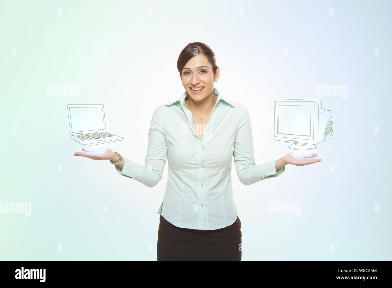 Geschäftsfrau beim Vergleich von Notebook und Desktop-PC Stockfoto