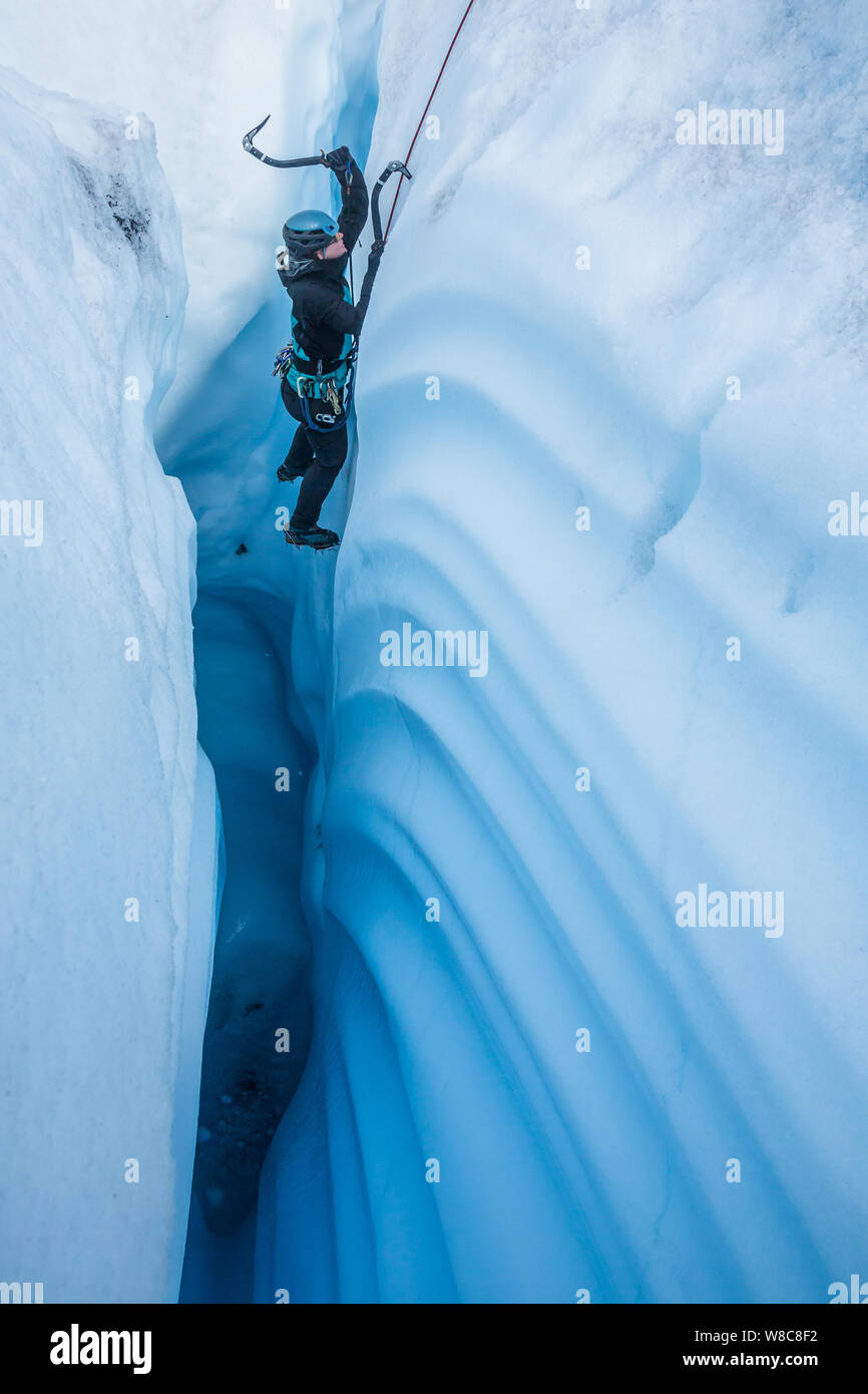 Frau Eis klettern auf der Matanuska Gletscher in Alaska. Sie ist in einen engen Canyon mit winkenden Linien, wie sie klettert abgesenkt. Stockfoto