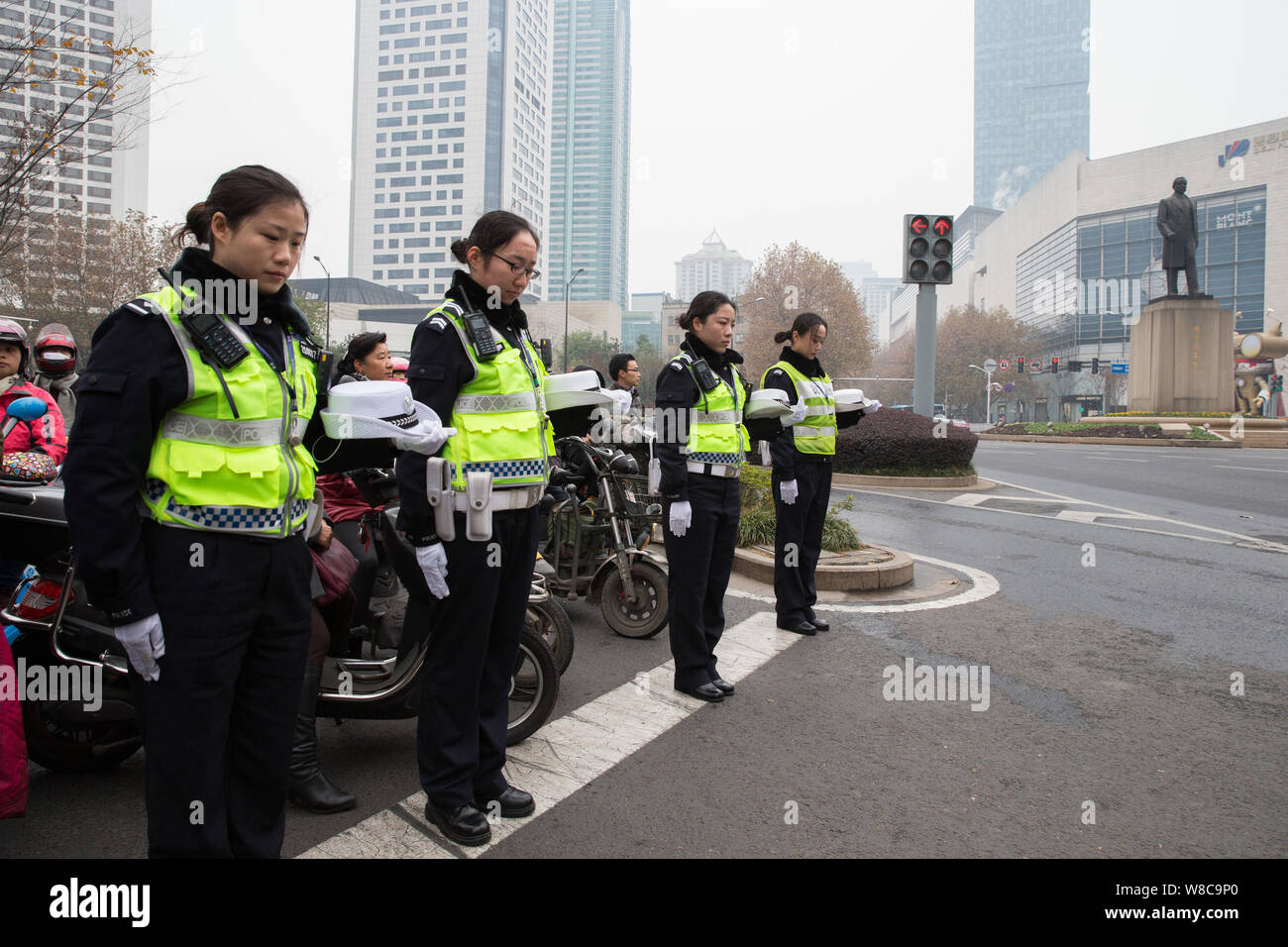 Chinesische Polizisten und Anwohner beobachten eine Schweigeminute für die Opfer des Massakers von Nanjing auf einer Straße zu mour in Nanjing city, Eas Stockfoto