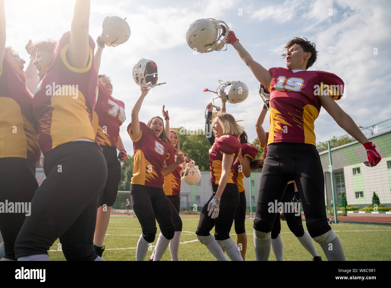 Foto von Frau Rugby Team mit erhobenen Händen an Kamera suchen Stockfoto