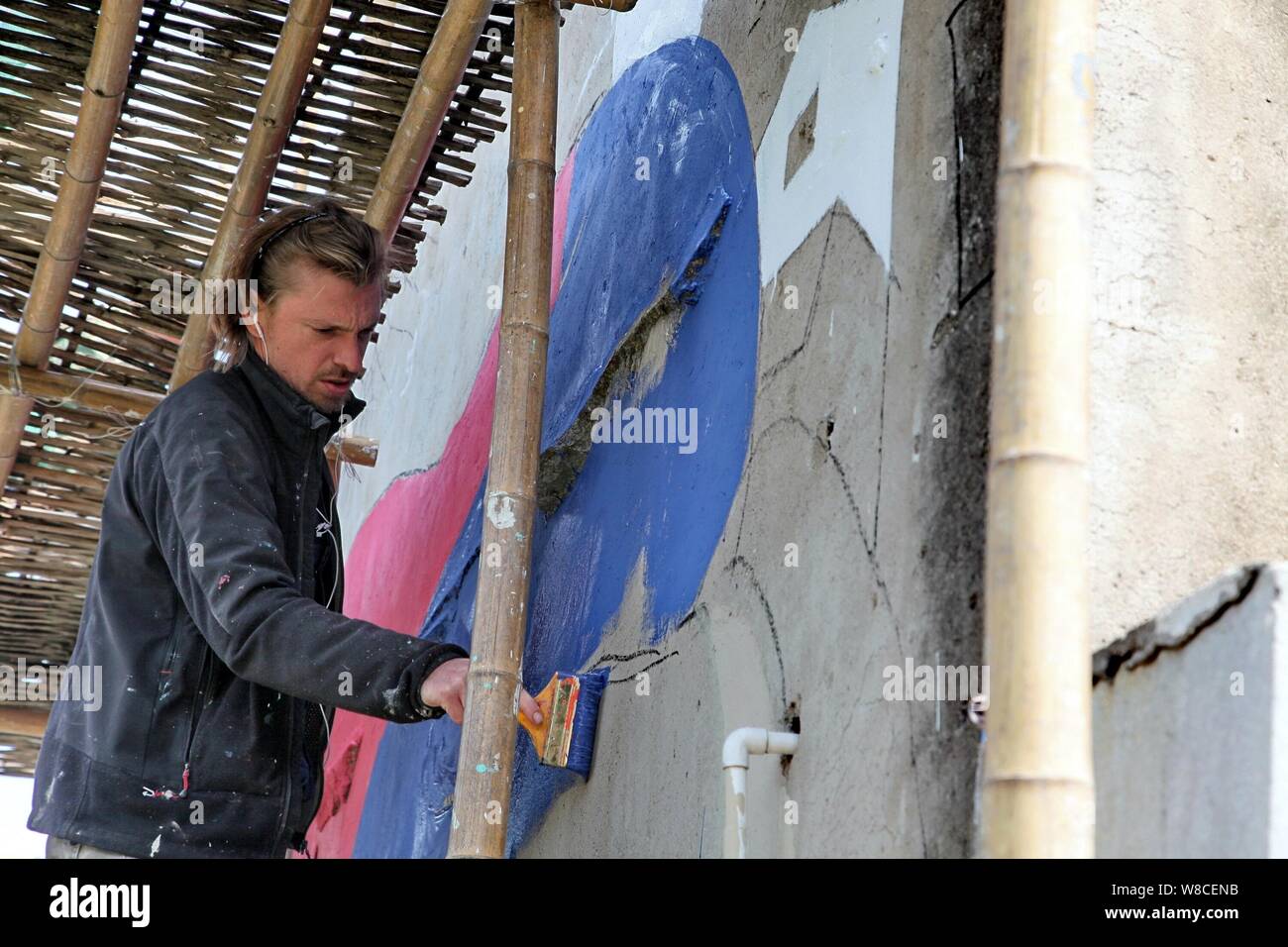 Französische Künstler Julien Seth Malland Farben an die Wand eines Hauses in Xinyi Dorf Fengjing Stadt in Jinshan district, Shanghai, China, 13. April 2015. Stockfoto