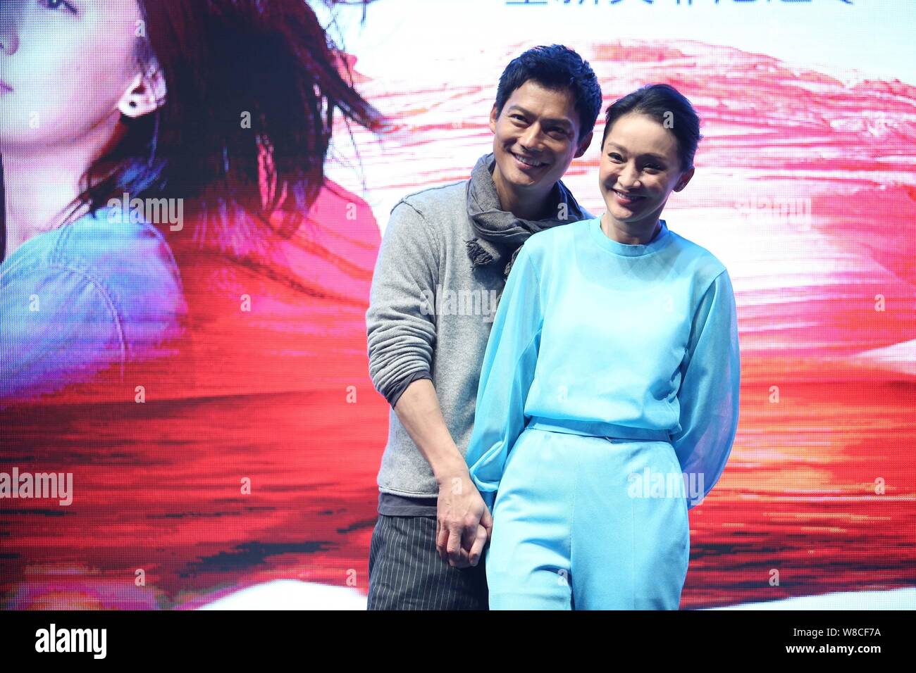 Chinesische Schauspielerin Zhou Xun, Front, und ihr amerikanischer Mann Archie Kao Lächeln während einer Premiere für die micro Film 'Dream Escape' zu fördern. Stockfoto