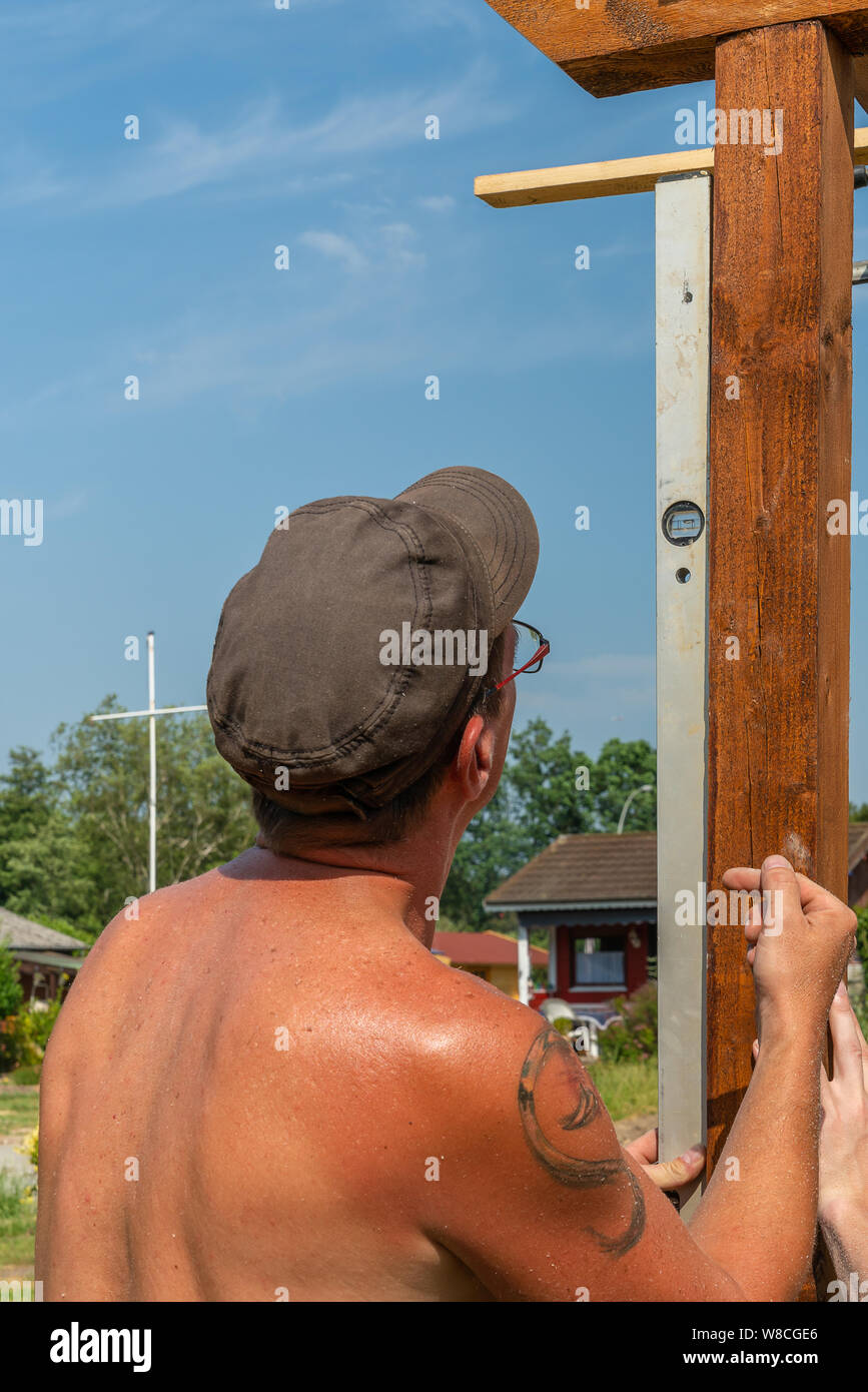 Ein Handwerker auf einen Holzbalken mit einer Wasserwaage Stockfoto