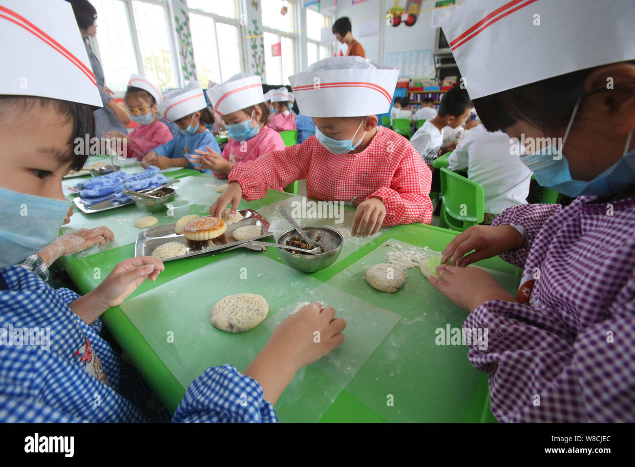 Chinesische Kinder machen mooncakes für Mid Autumn Festival in einem Kindergarten in Tianjin City, Central China Provinz Henan, 25. September 2015. Zu Stockfoto