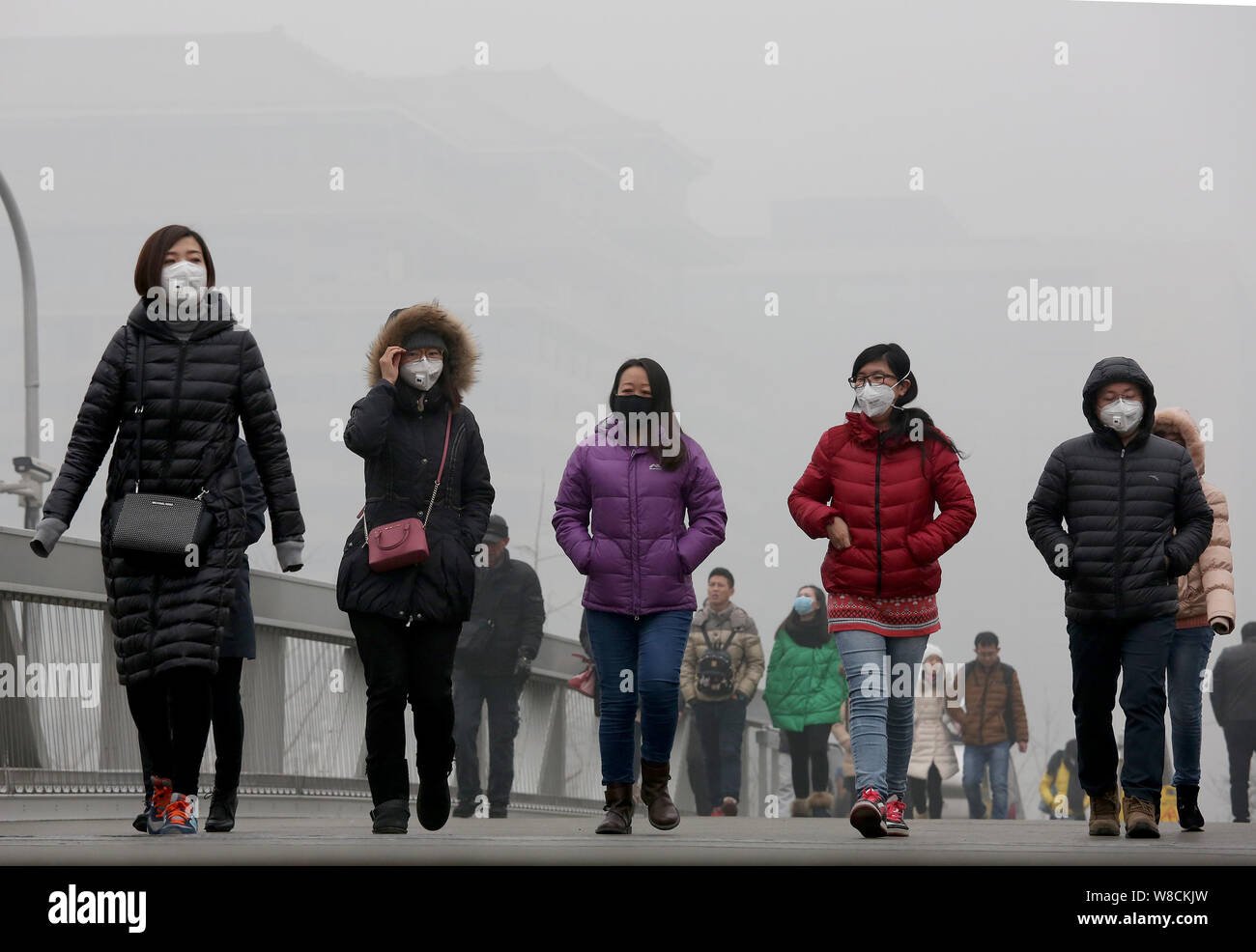 ---- Fußgänger, von denen die meisten Gesicht-masken tragen, zu Fuß auf einer Straße in heavy Smog in Peking, China, 25. Dezember 2015. Peking Bewohner mehr gekauft Stockfoto