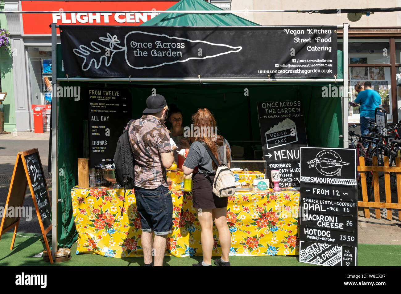 Menschen, die im Sommer an einem Street Food Stall für vegane Küche Lebensmittel kaufen York North Yorkshire England Großbritannien Großbritannien Großbritannien Großbritannien Stockfoto