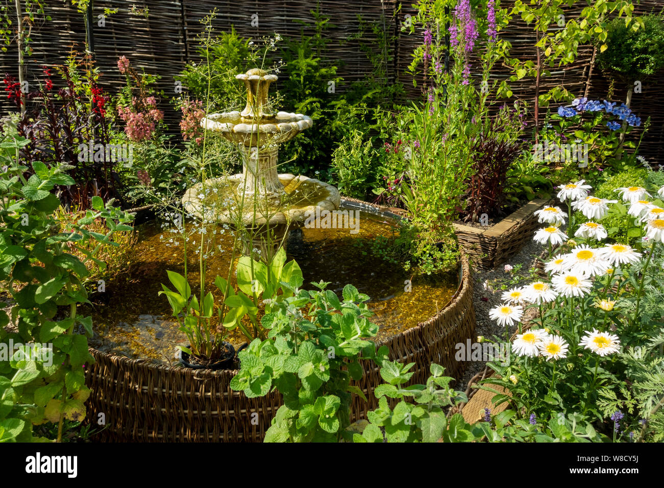 Kunstvolle Wasserbrunnen Teich und Pflanzen in einem Ferienhaus Blumengarten im Sommer England Großbritannien Großbritannien GB Großbritannien Stockfoto