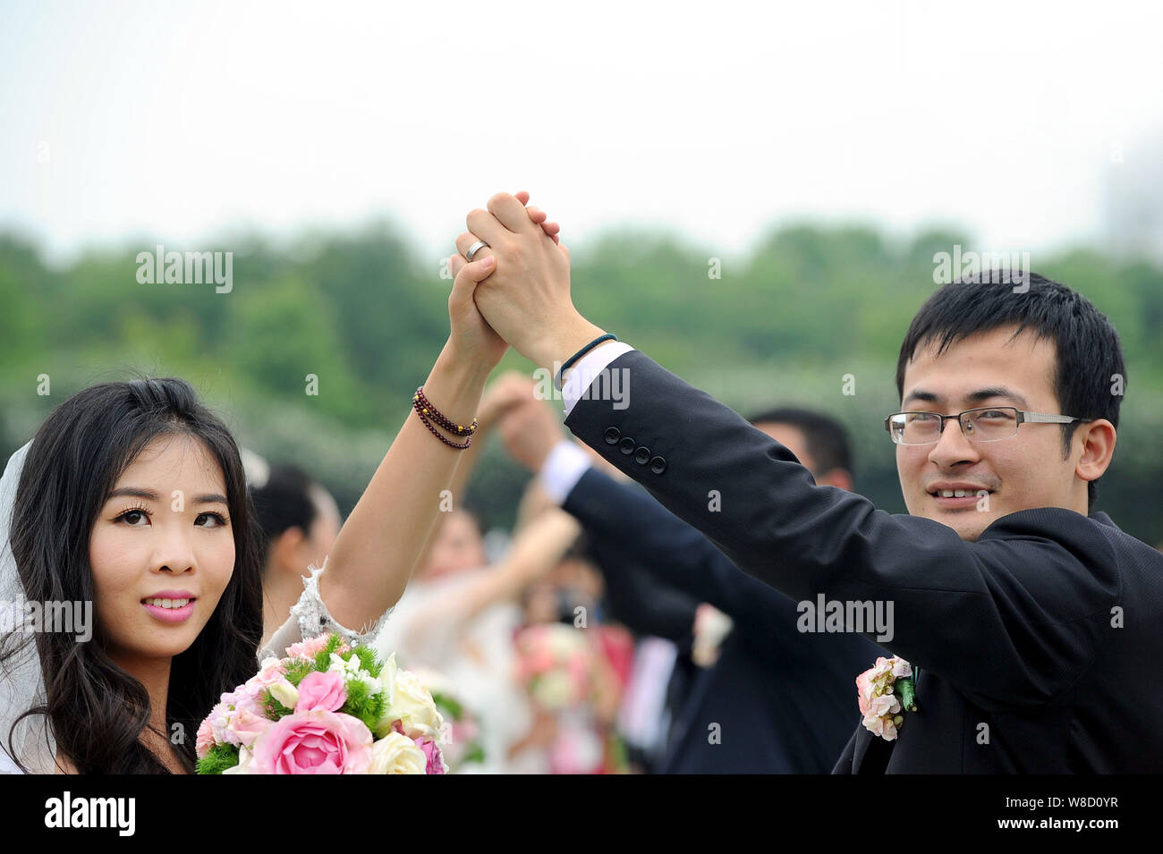 Paare der Jungvermählten nehmen Teil an eine Alumni Gruppe Hochzeit im Zijingang Campus der Zhejiang Universität in Hangzhou City, East China Zhejiang provi Stockfoto