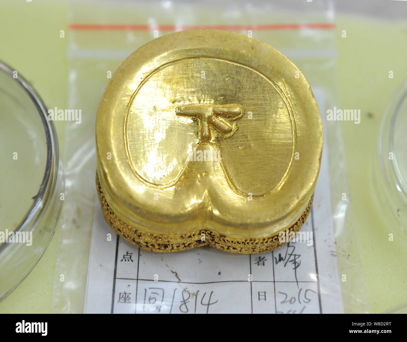 Ein Huf-förmige Goldbarren mit einem chinesischen Zeichen 'Xia", also 'Down' in Englisch, aus dem Grab des "Haihunhou" (Marquis von Haihun) zurückgehend auf. Stockfoto