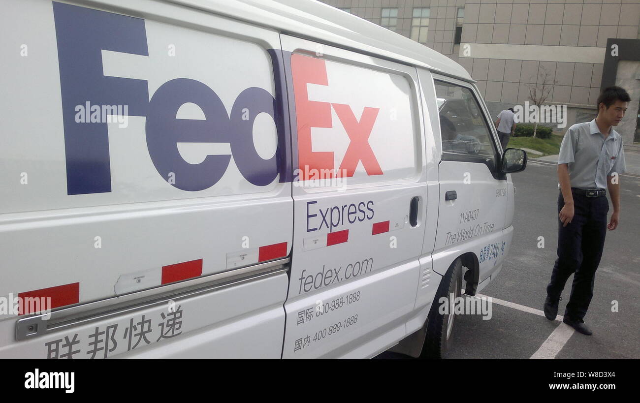 ---- Ein chinesischer Mitarbeiter an einen FedEx Express Lieferung Auto in Nanjing City, East China Jiangsu Provinz, 28. August 2013. FedEx Corp. ist zu b Stockfoto