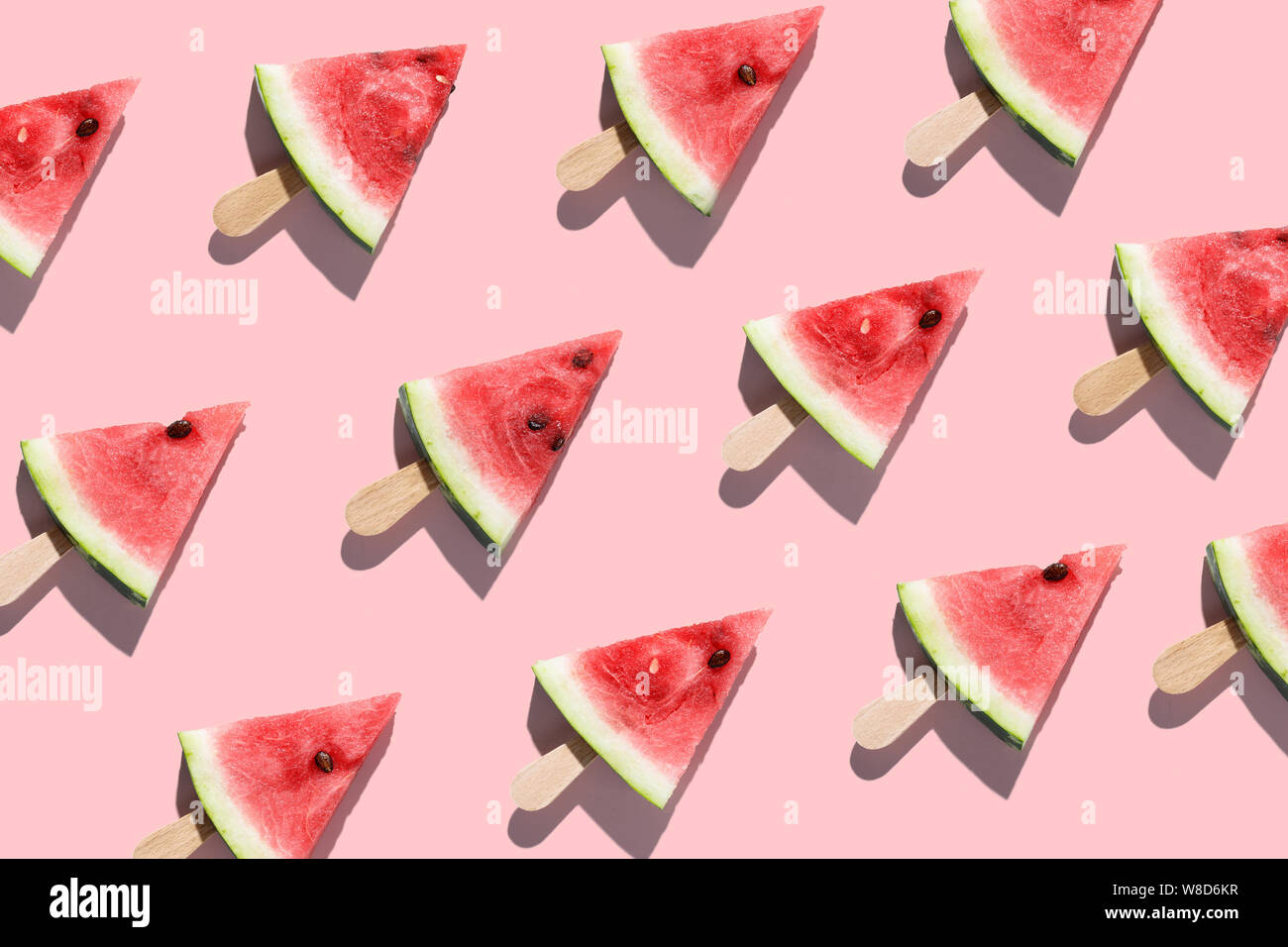 Aufgeschnittene Wassermelonen auf einem rosa Hintergrund angeordnet Stockfoto
