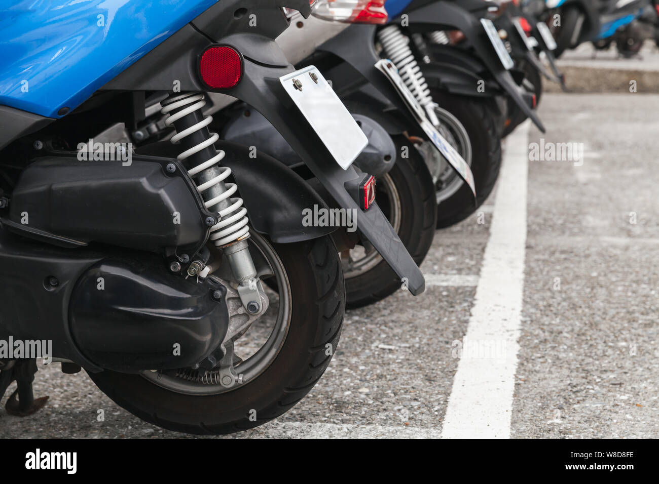 Moderne Stadt Roller stehen in einer Reihe auf einem städtischen Parkplatz, Nahaufnahme Foto mit selektiven Fokus Stockfoto