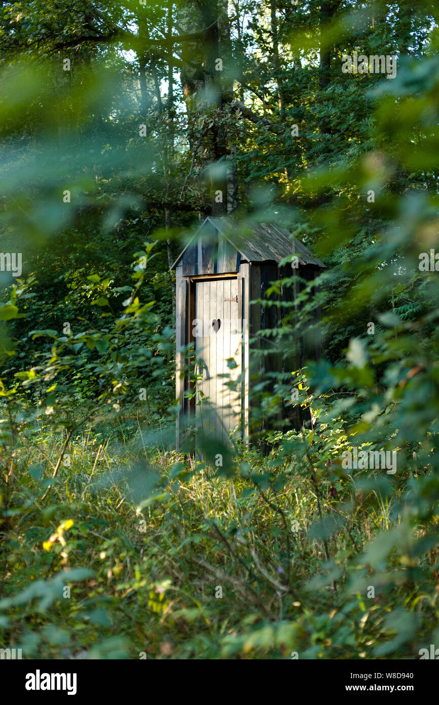 Gerahmte Blick über den privaten Outdoor Holz- WC in Form eines Herzens im Wald Stockfoto