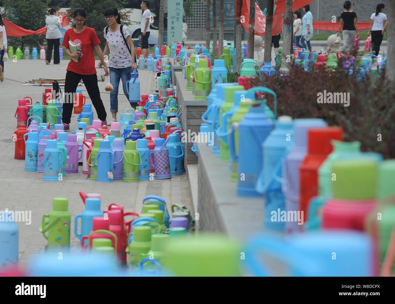 Bunte Thermoskannen sind von den Studenten vor der öffentlichen Wasserversorgung Zimmer auf dem Campus der Universität für TCM in Shanxi Jinzhong Stadt,Chi platziert Stockfoto