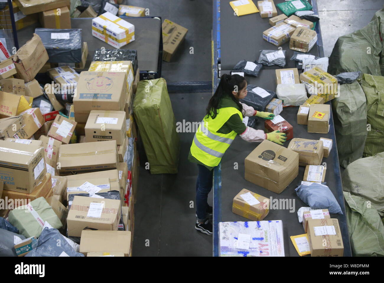 Ein chinesischer Arbeiter sortiert Pakete, von denen die meisten aus online einkaufen, bei einer Distribution Center Best Express in Chongqing, China, 16. November 2015 Stockfoto
