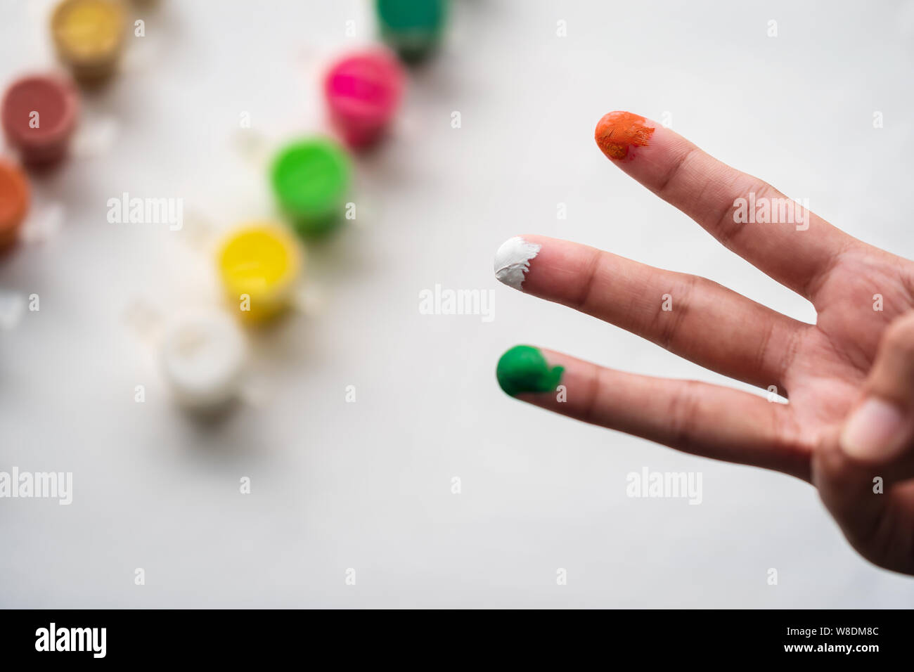 Closeup Schuß von Person, Hand bemalt mit Orange oder Safran, Weiß, Grün mit Wasser Farben auf weißem Hintergrund. Konzept für Indische Stockfoto