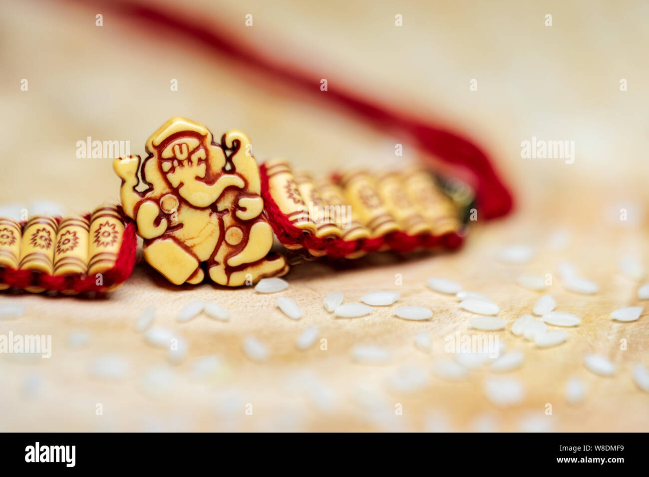 Lord Ganesha handgemachten Armband mit Reiskörner für rituelle Zwecke. Indische Rakshabandhan festival Hintergrund Konzept. Stockfoto