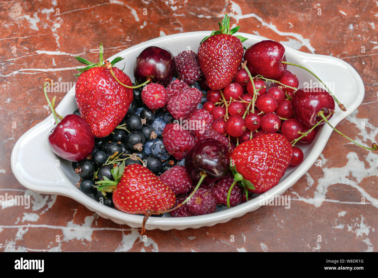 Belgische organische Beeren in weiße Schüssel aus Keramik Tabelle, Ansicht von oben in den natürlichen Innenbeleuchtung Stockfoto