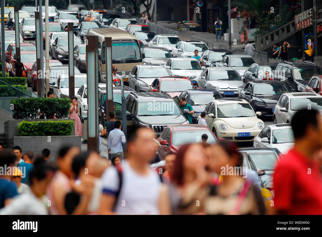 ---- Fußgänger vorbei an Massen von Fahrzeugen im Stau im Berufsverkehr in Chongqing, China, 16. Mai 2015. Bewohner von Chongqing genießen Sie t Stockfoto