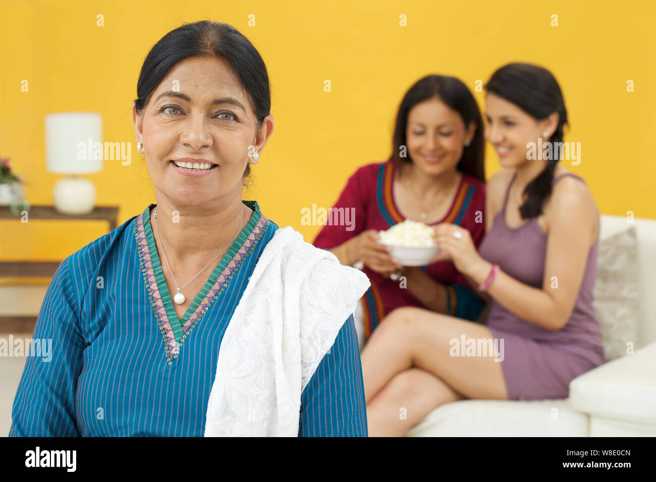 Alte lächelnde Frau und ihre Familie im Hintergrund Stockfoto