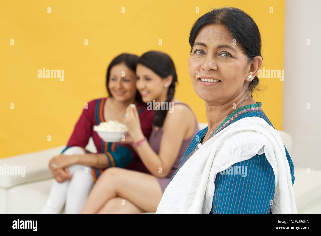 Alte lächelnde Frau und ihre Familie im Hintergrund Stockfoto