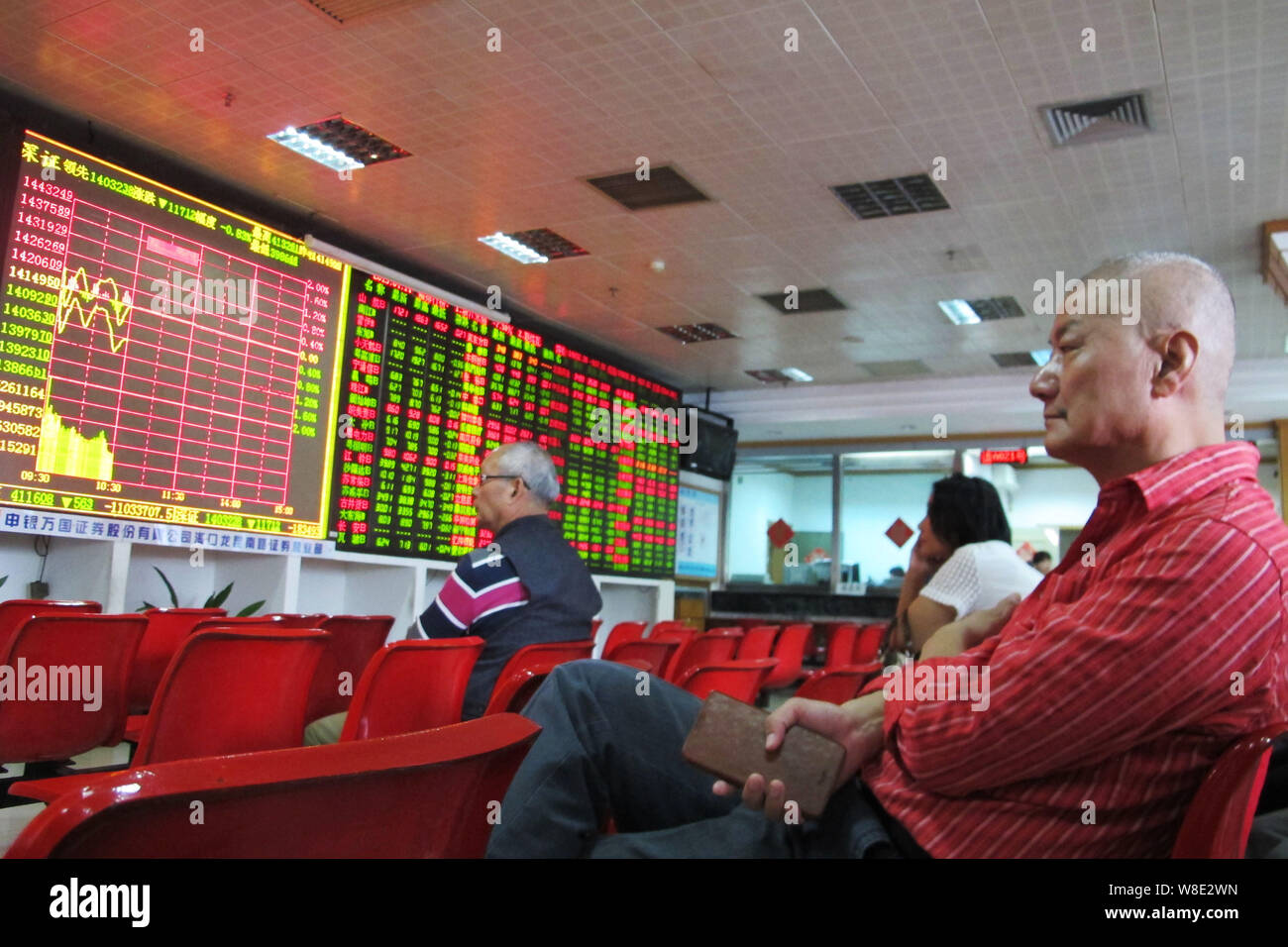 Chinesische Investoren betrachten die Shenzhen Composite Index und die Preise der Aktien (rot für Preis steigt und grün für den Preis fallen) auf einer Börse brokerage Ho Stockfoto