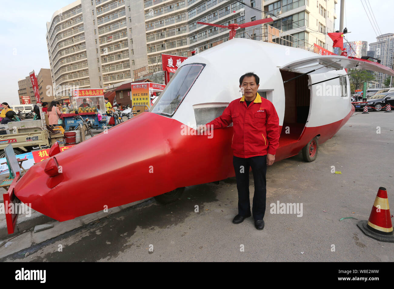 Pensionierte chinesischen Ingenieur Yuan Jingying wirft mit seinen hausgemachten Hubschrauber-förmige Fahrzeug auf einer Straße in der Stadt Zhengzhou, Provinz Henan, China Stockfoto