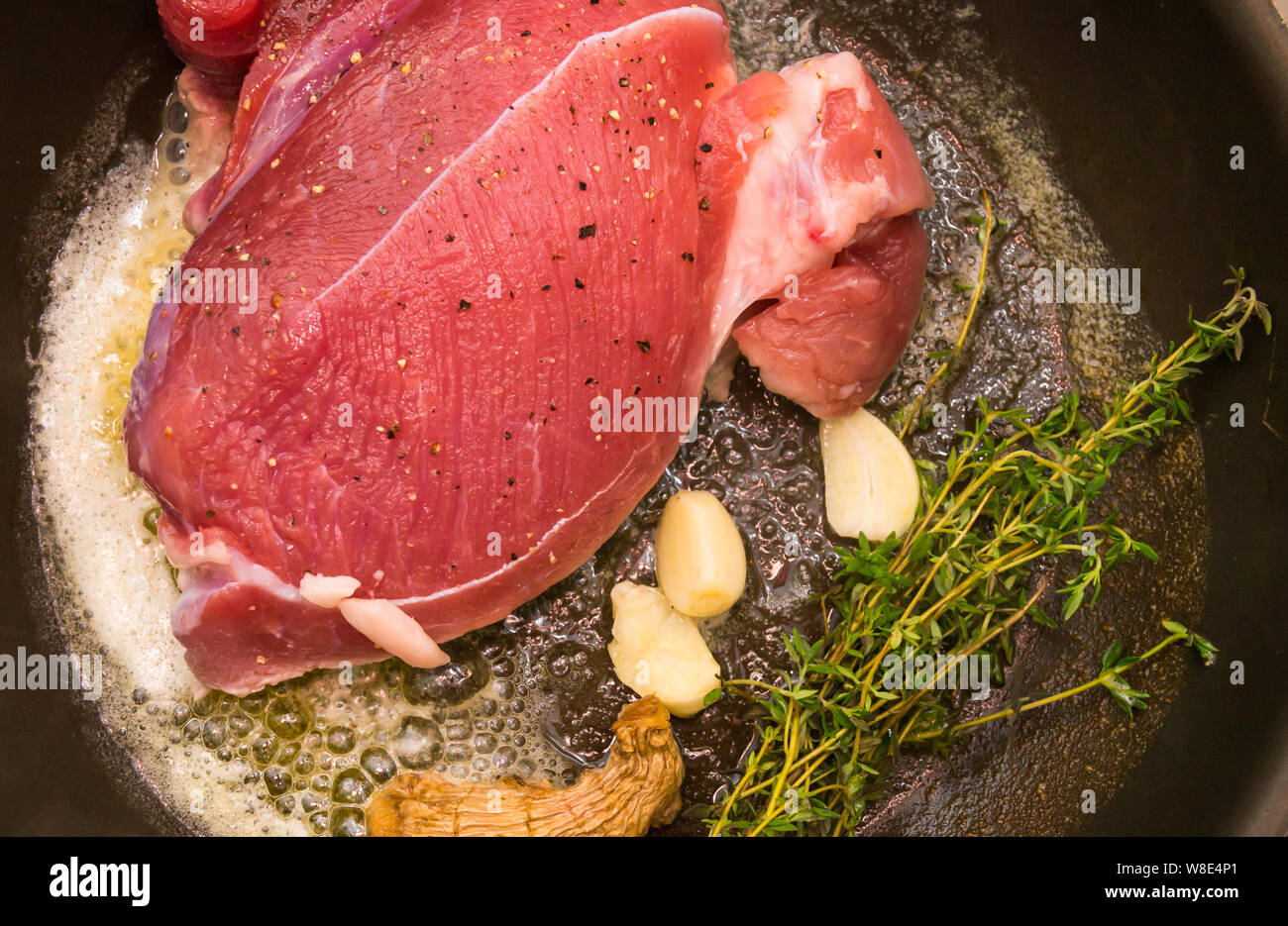 Roastbeef in der Pfanne mit Butter, Knoblauch, Ingwer und Thymian Stockfoto