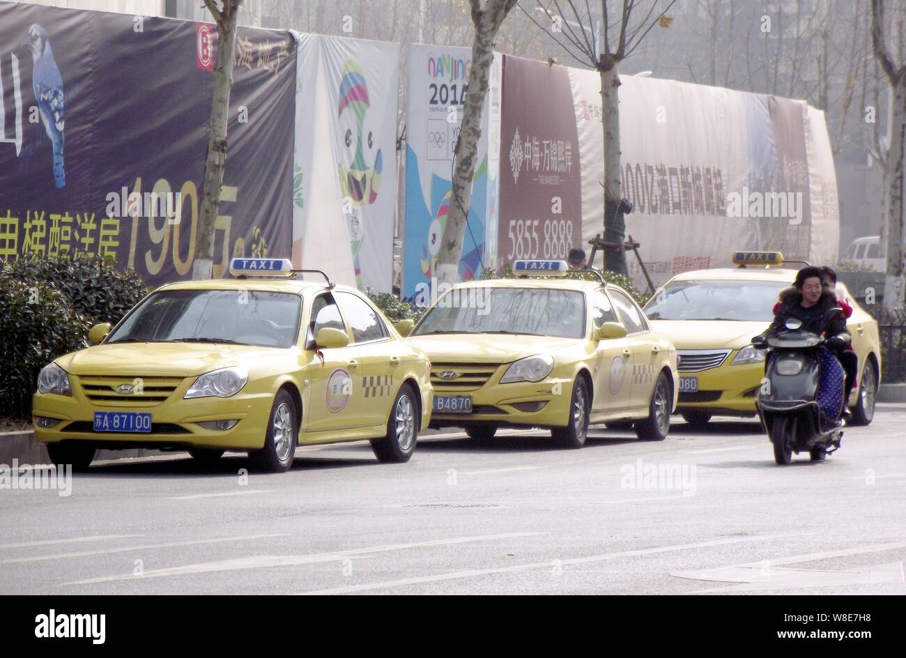 Radfahrer fahren an Taxis entlang einer Straße geparkt, während Ihre Treiber auf Streik in Nanjing city gehen, im Osten der chinesischen Provinz Jiangsu, 10. Januar 2015. Regul Stockfoto