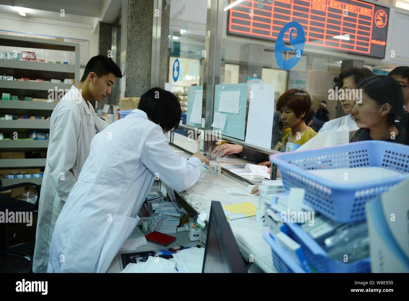 ------ Chinesische medizinische Arbeiter dienen, die Patienten in der Ambulanz eines Krankenhauses in Qingdao, Provinz Shandong, China, 31. März 2014. Ein docum Stockfoto