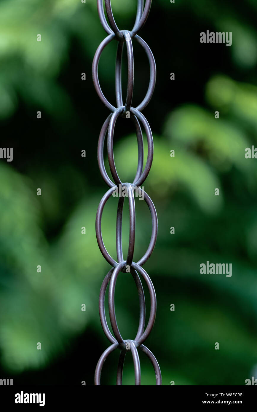 In der Nähe von Metall Kette links und eine verschwommene Grüne bokeh Hintergrund Stockfoto