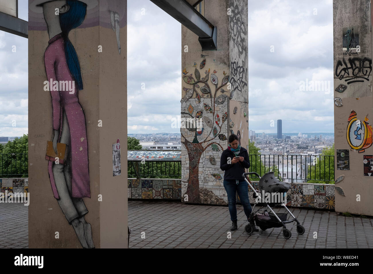 Das tägliche Leben in Paris: Mutter und Kind am Aussichtspunkt in der Pariser Nachbarschaft Belville mit dem Turm Montparnasse in der Ferne. Stockfoto
