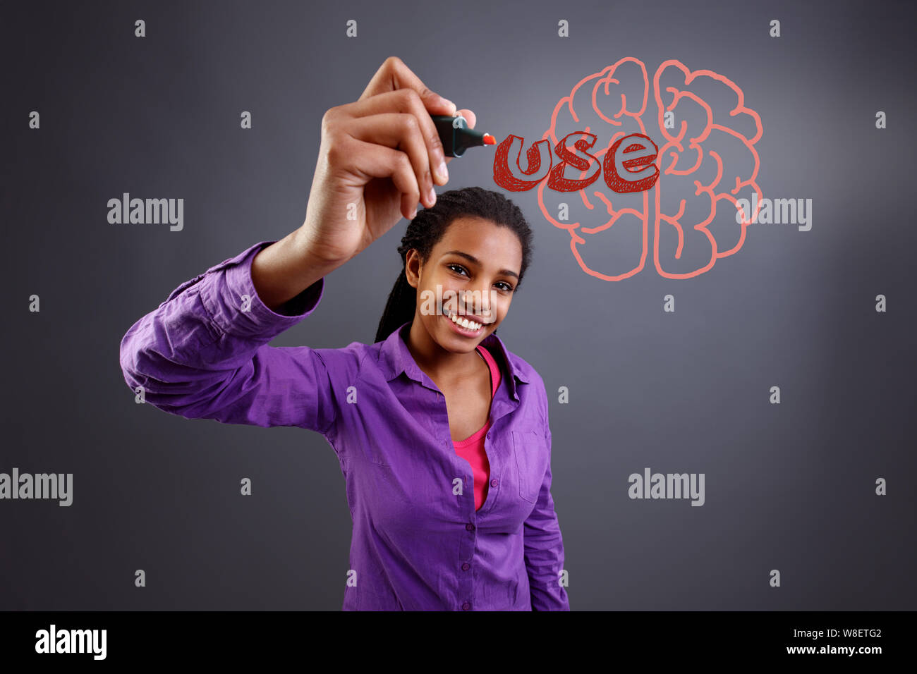 Lächelnd Schülerin Schreiben verwenden Sie das Gehirn auf transparenten Wand Stockfoto