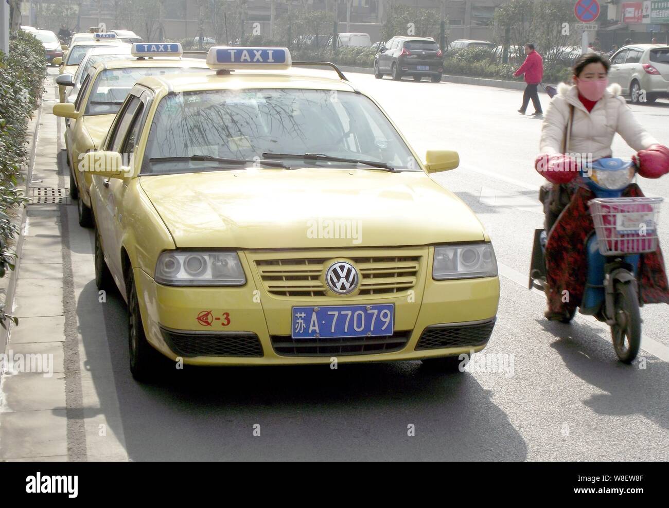 Ein Radfahrer fährt Vergangenheit Taxis entlang einer Straße geparkt, während Ihre Treiber auf Streik in Nanjing city gehen, im Osten der chinesischen Provinz Jiangsu, 10. Januar 2015. Reg Stockfoto