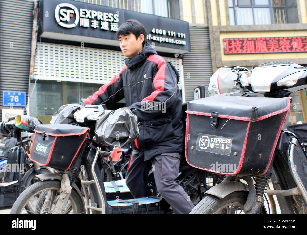 Eine Chinesische deliveryman von SF Express fährt mit dem Elektrofahrrad ein Distributionszentrum in Nanjing Stadt zu verlassen, der ostchinesischen Provinz Jiangsu, 1. Februar Stockfoto