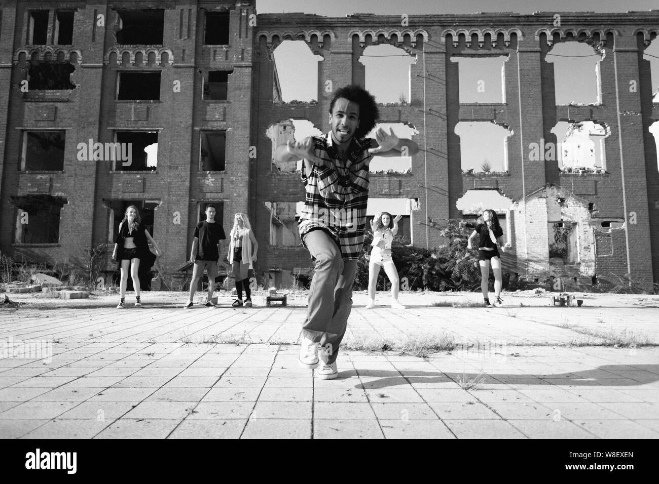 Von der Sonne beschienen Young African American Mann aus seinen Hip-Hop-Tanz-Routine anmutig auf dem Pflaster ein urbaner Platz beenden. Stockfoto
