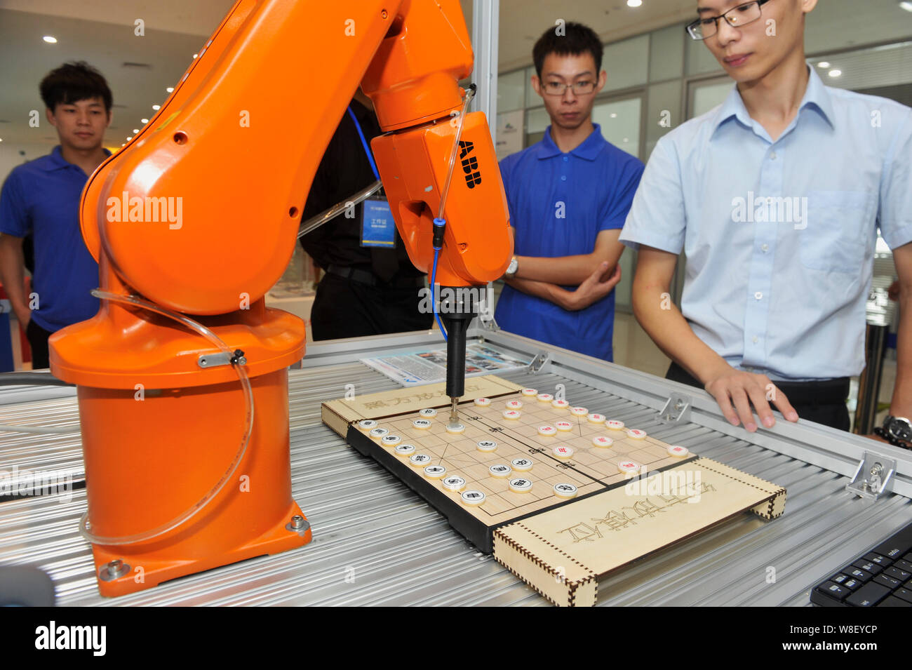 Besucher Blick an einem ABB-Roboter Arm spielen Chinesisches Schach während der 1. China International Internet Plus Ausstellung in Foshan City, South China Guan Stockfoto