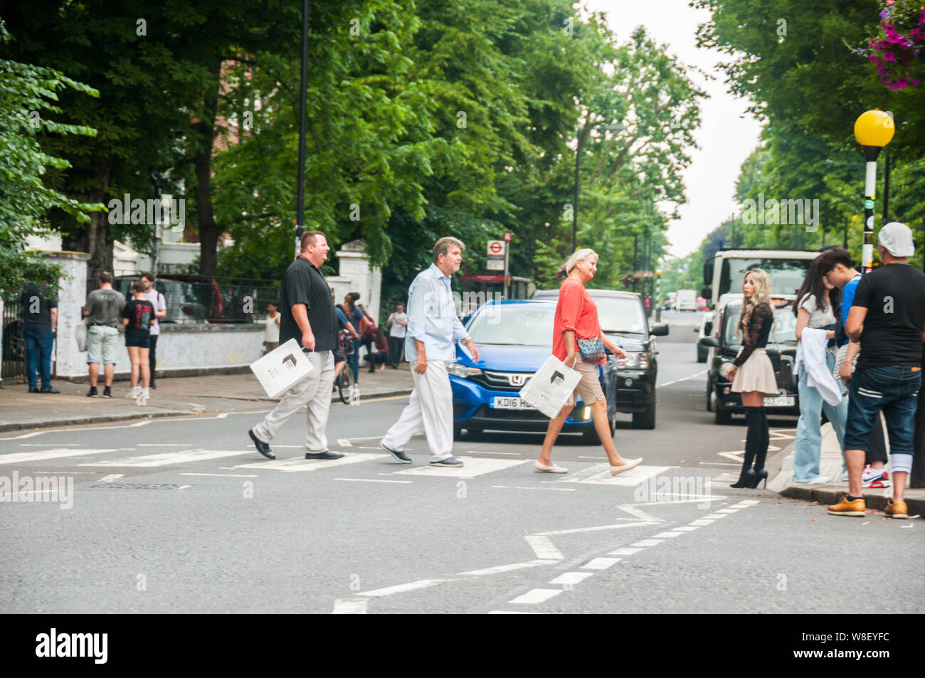 Touristen auf den Spuren der Beatles auf dem Fußgängerüberweg vor der Aufnahme in den Abbey Road Studios. Stockfoto