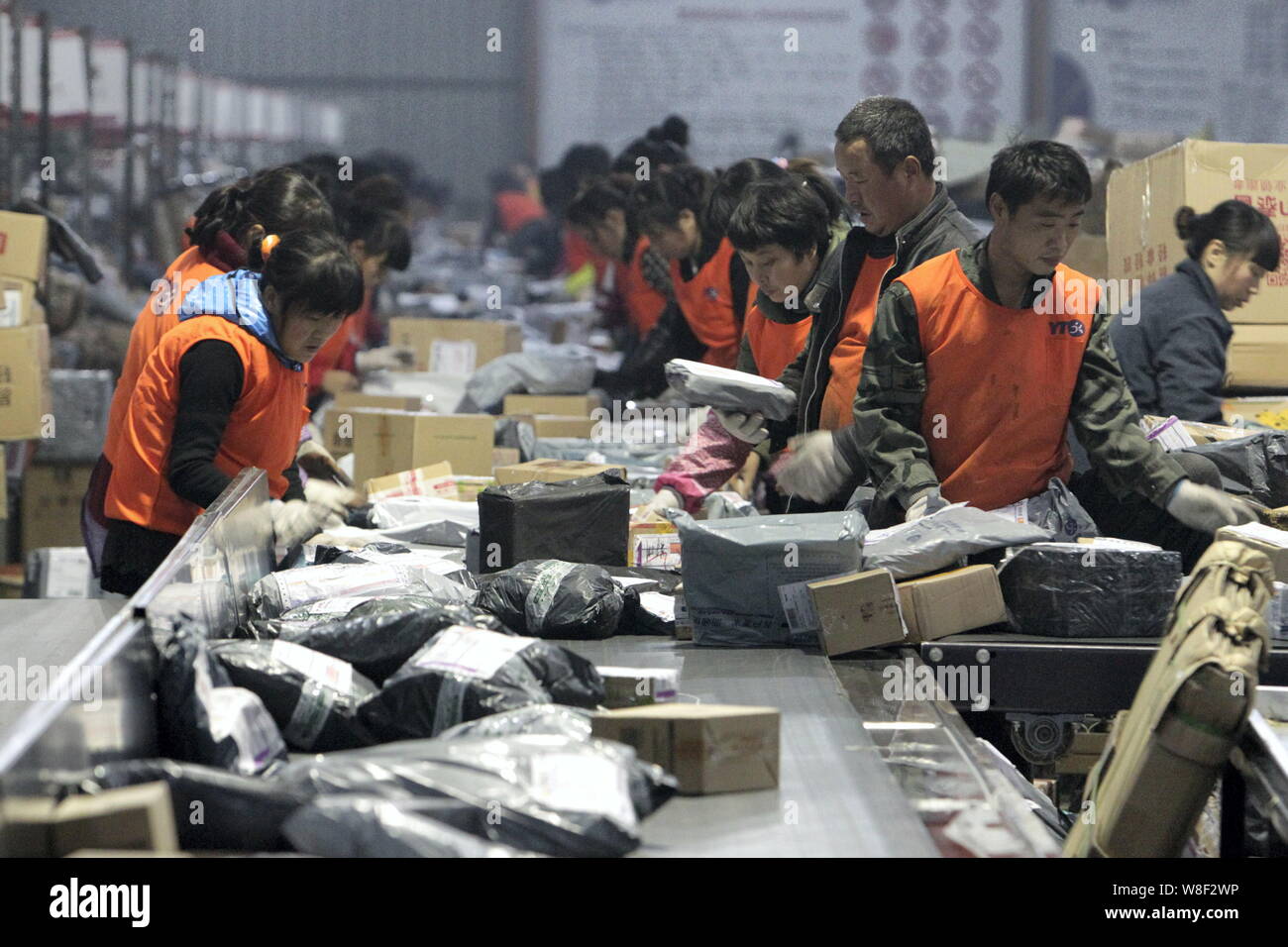 ------ Chinesische Arbeiter sortieren Pakete bei einer Verteilung von YTO Express in Zhengzhou City, Central China Provinz Henan, 15. November 2014. Th Stockfoto