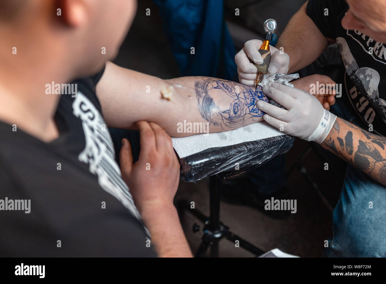 Junge Kerl erhält ein frisches Tattoo ein Tattoo Convention. Stockfoto