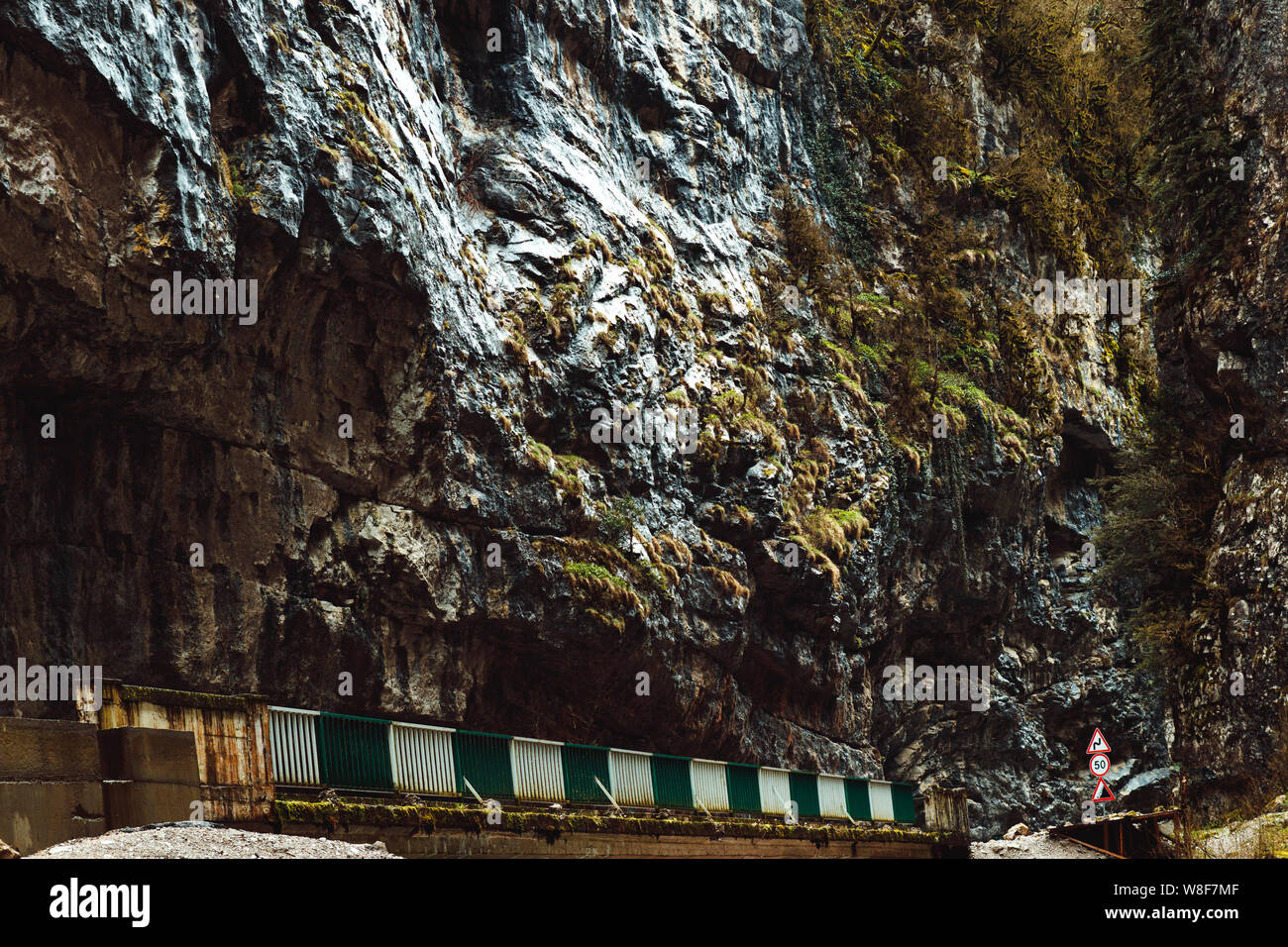 Brücke über den Fluss. Stein Tasche Abchasien im Frühjahr. Canyon Road von Felsen umgeben. Bäume auf einem Bergrücken wachsen. Steilen Hügeln oberhalb der Straße. Unus Stockfoto