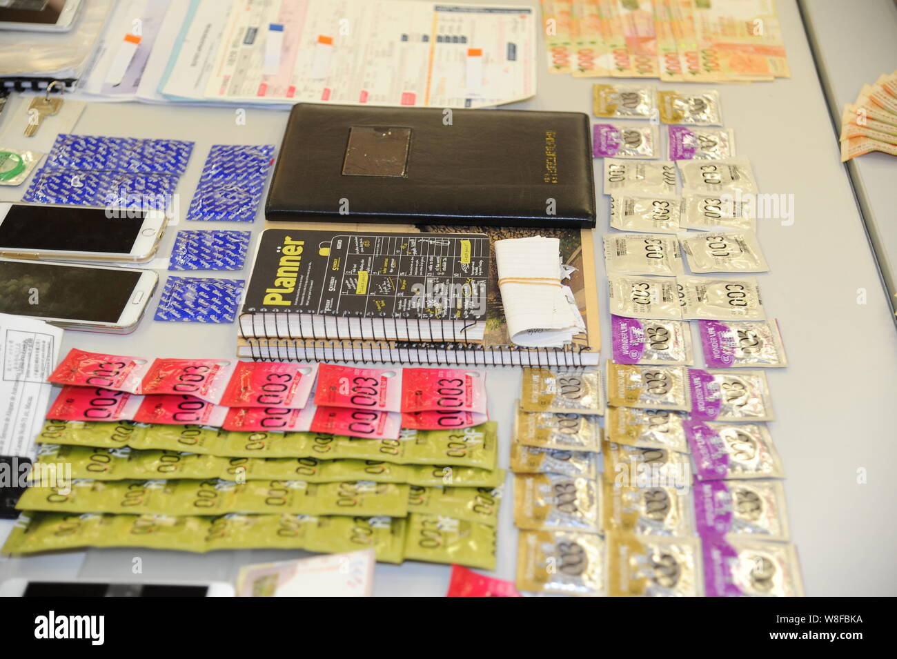 Kondome, Smartphones und beschlagnahmten Notebooks sind angezeigt, nach dem Mitglieder einer Bande sind wegen des Verdachts der Verwaltung einer Prostitution Ring während einer Pr verhaftet Stockfoto